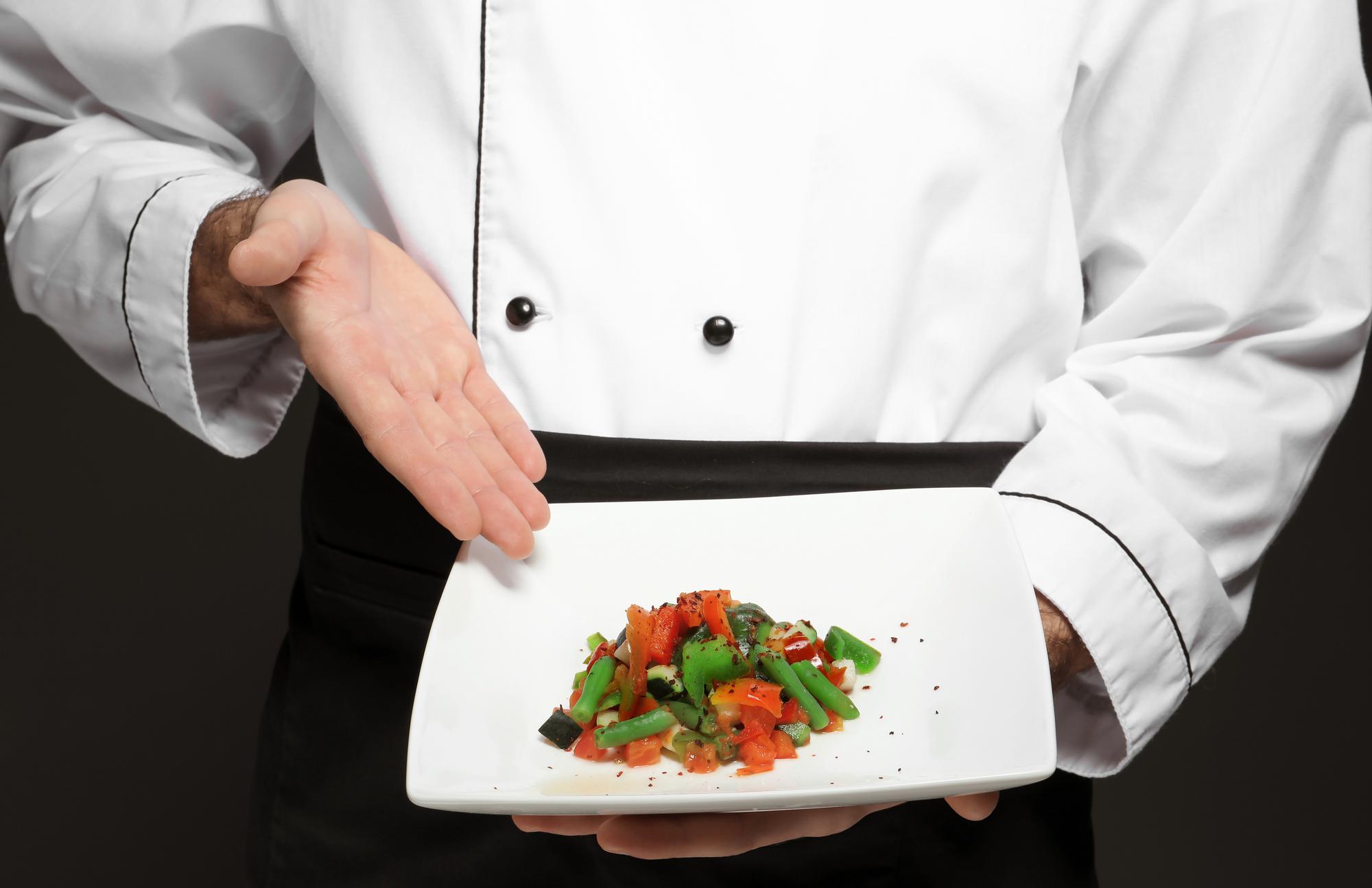 Instructor demonstrating plated dish in a modern studio